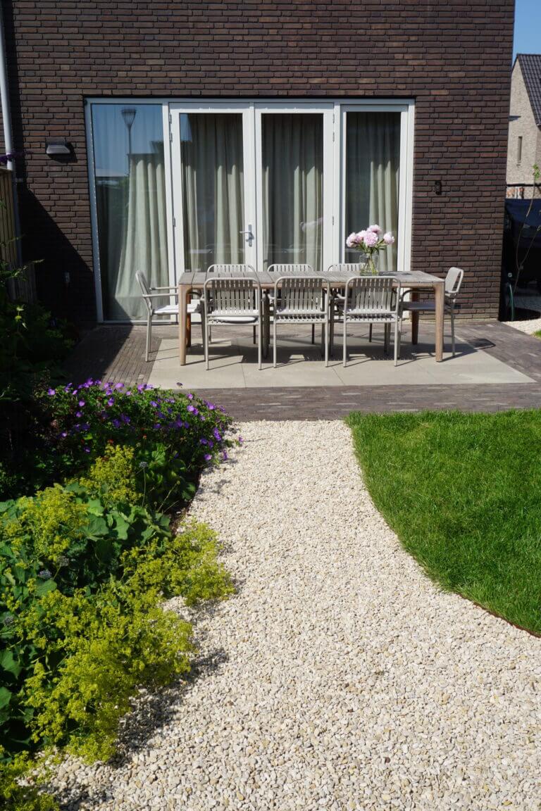 Tuintegels combineren met grind, gras of houten vlonders